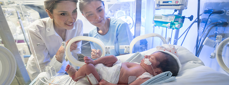 newborn with hospital staff